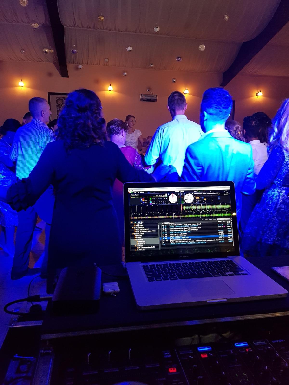 Laptop DJ în fața ringului de dans și a invitaților
