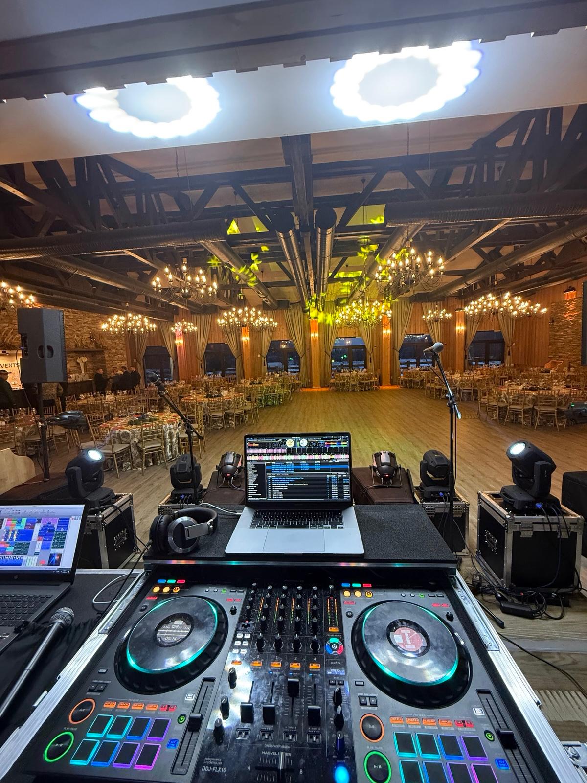 Consolă DJ și lumini pregătite într-o sală rustică